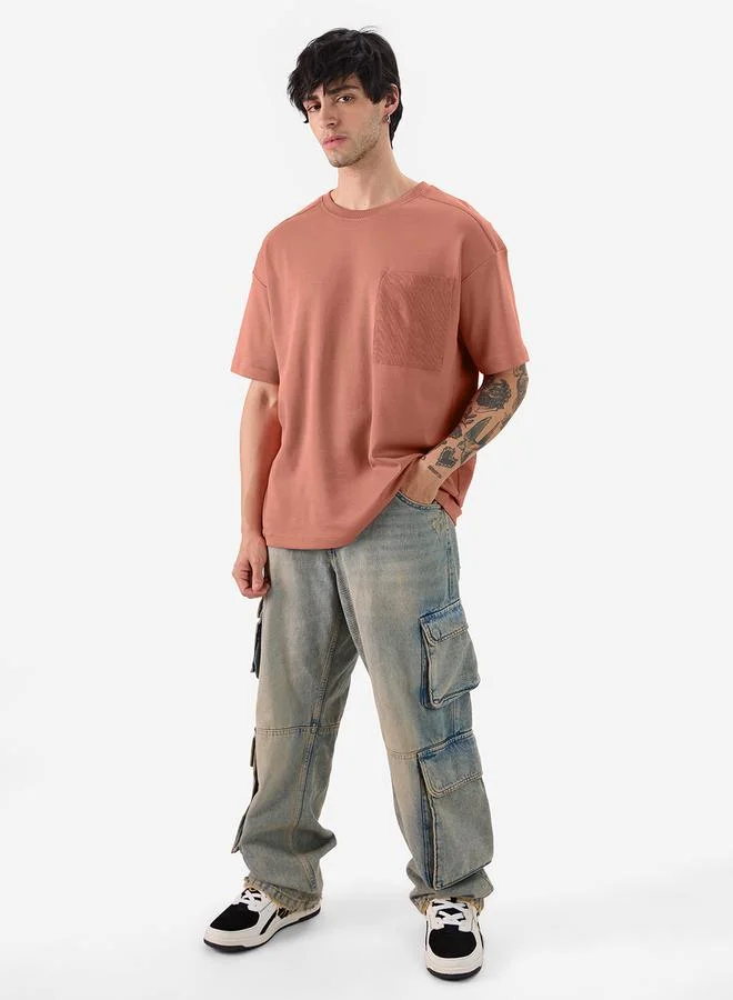 ذا سوليد ستور تيشيرت واسع مع جيب مُرقع