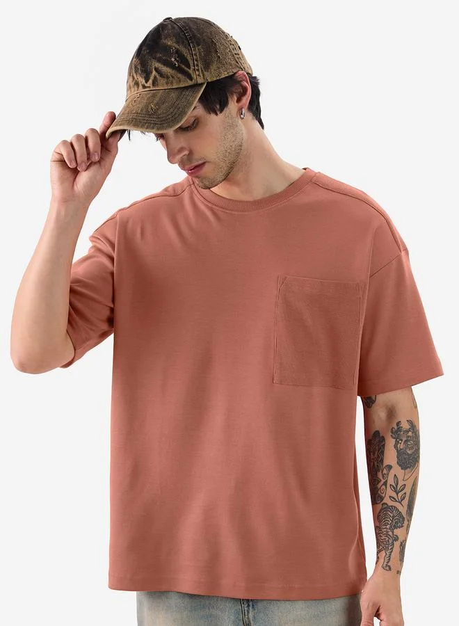 ذا سوليد ستور تيشيرت واسع مع جيب مُرقع