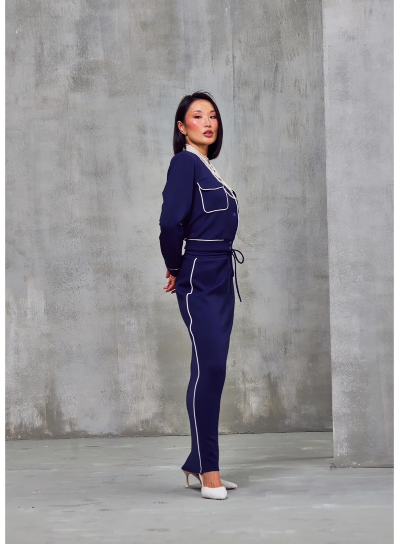 أشيتا فرنانديز جاكيت بسحاب بلون أزرق داكن من قماش الجيرسي الفاخر بخياطة متباينة