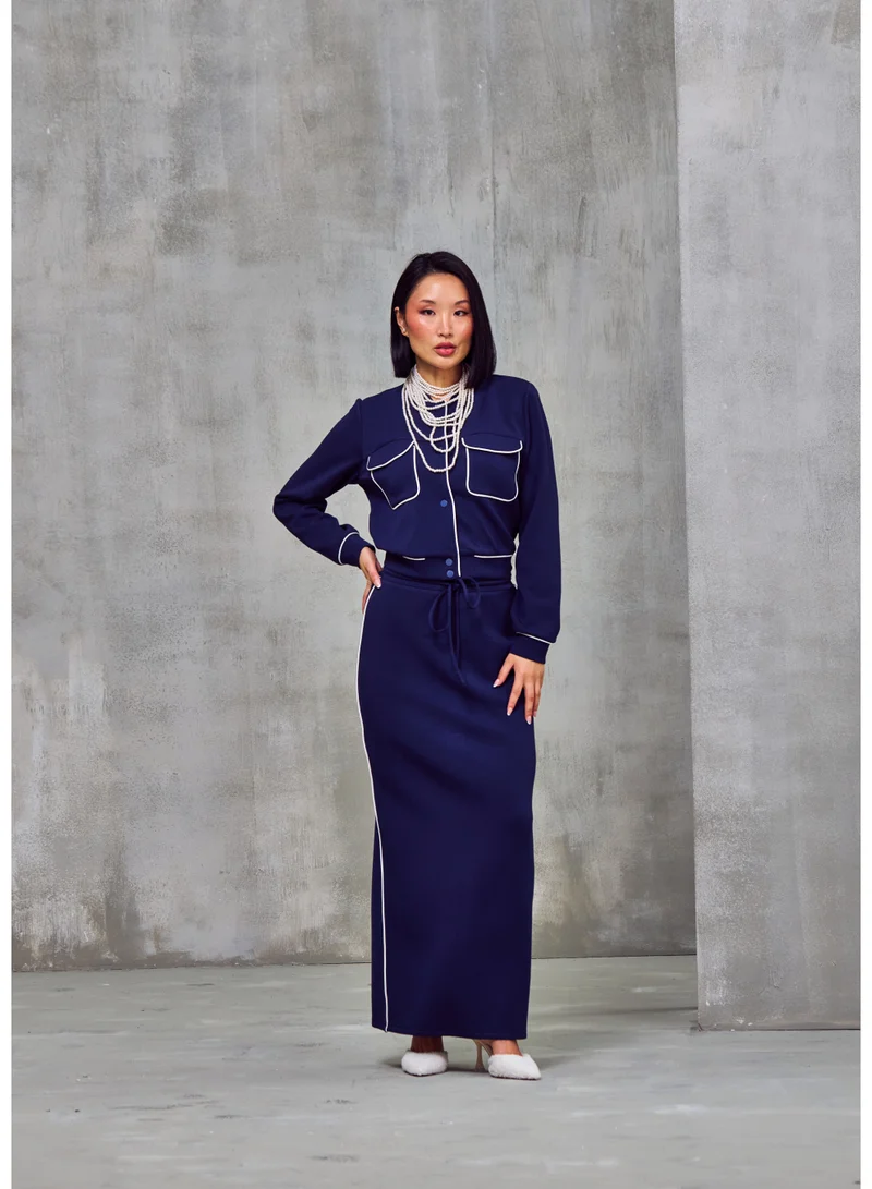 أشيتا فرنانديز جاكيت بسحاب بلون أزرق داكن من قماش الجيرسي الفاخر بخياطة متباينة