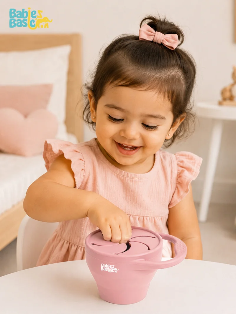 بابيز_بيسك **بيبيز بيسك** كوب/علبة وجبات خفيفة سيليكون قابلة للطي للأطفال – **زهري فاتح (بلش)**.