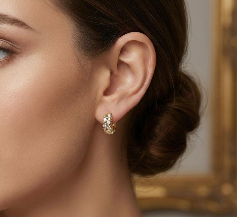 حلق ذهبي أنيق بتصميم الزيجزاج العصري، مرصع بفصوص زركون دائرية تمنحه لمعاناً استثنائياً. قطعة جريئة ومميزة تضفي لمسة من الحيوية والجمال على مظهرك. - Image 2