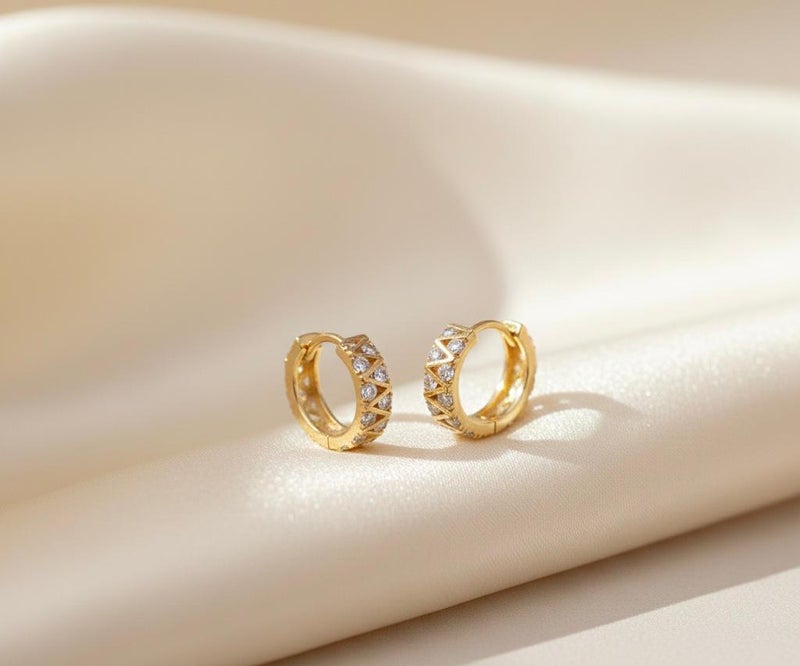 حلق ذهبي أنيق بتصميم الزيجزاج العصري، مرصع بفصوص زركون دائرية تمنحه لمعاناً استثنائياً. قطعة جريئة ومميزة تضفي لمسة من الحيوية والجمال على مظهرك. - Image 4