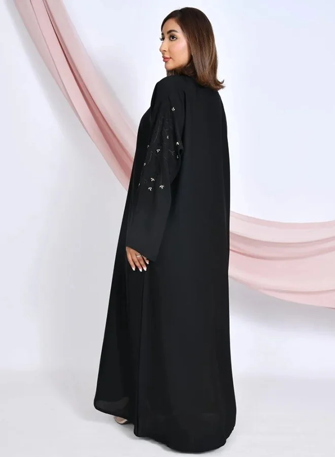 HAWRAA ABAYA Black quarter-flared closed abaya with snap buttons, adorned with embroidery on the sleeves