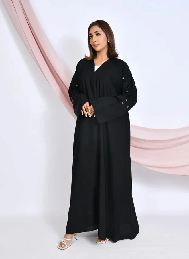HAWRAA ABAYA Black quarter-flared closed abaya with snap buttons, adorned with embroidery on the sleeves