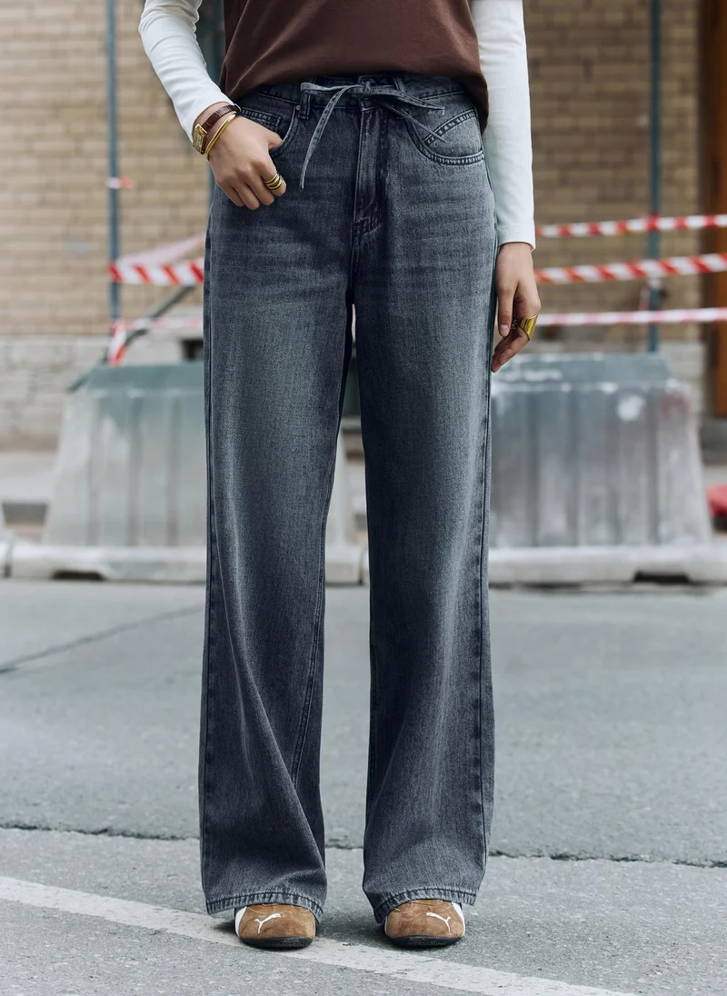 Loose distressed jeans with waist ties