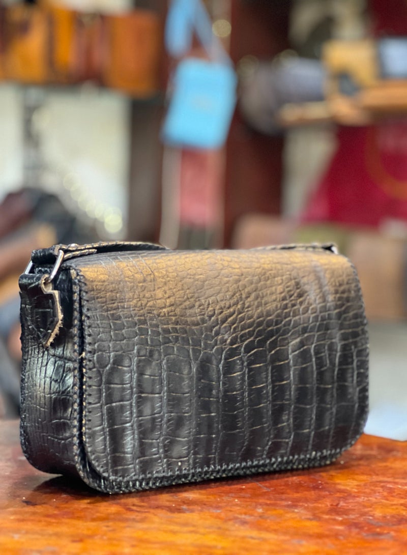 📌 شنطة جلد لازار طبيعي هاند ميد – حجم صغير، تفاصيل كبيرة 👜 مقاس 18×22 سم – تصميم أنيق عملي خفيف وسهل الحمل 💼 مصنوعة يدويًا من جلد لازار طبيعي 100% بلمعة فخمة ومظهر كلاسيكي 🔒 مزودة بـ يد + حزام كروس + 3 جيوب داخلية + بطانة قطيفة ناعمة + قفل ماجنتك 🪡 تقفيل يدوي متقن، تناسب الخروجات اليومية أو المناسبات الخاصة  ✔️ شنطة عملية وعصرية في نفس الوقت ✔️ خفيفة لكنها تشيل كل احتياجاتك ✔️ قطعة أنيقة من Holy of Holies Store – لأنك تستاهلي الأفضل  📦 متاحة الآن والتوصيل متاح لجميع المحافظات - Image 1