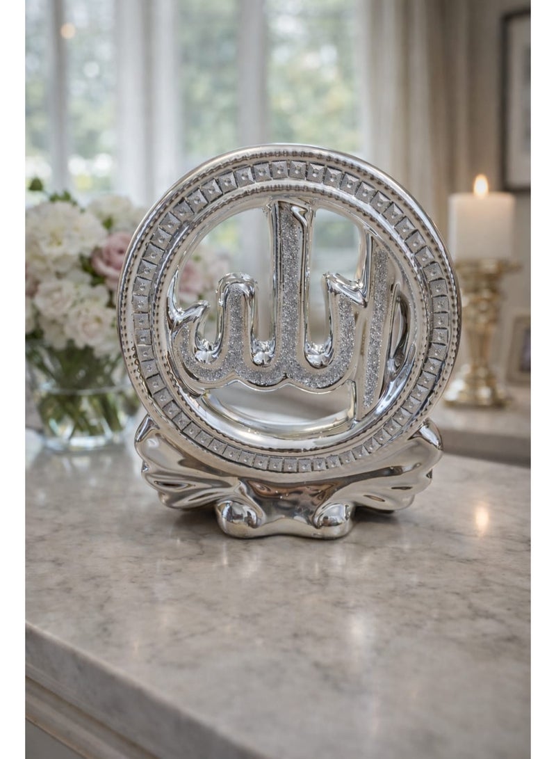 A breathtaking spiritual masterpiece featuring the sacred name of "Allah" enclosed in a sparkling circular frame. This metallic silver decor piece combines modern craftsmanship with traditional calligraphy, resting on an elegant, flowing base. - Image 1