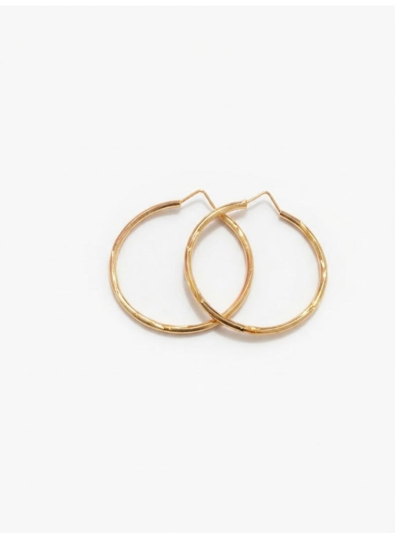Luxuria Women's gold twisted hoop earrings featuring a geometric pattern that adds extra sparkle and modern appeal. Jewelry for women. - Image 1