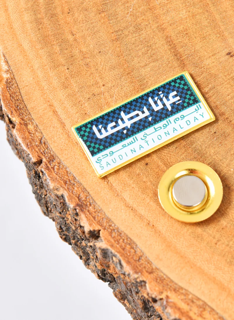 HAWRAA ABAYA A wide rectangular brooch with the logo of our pride, green