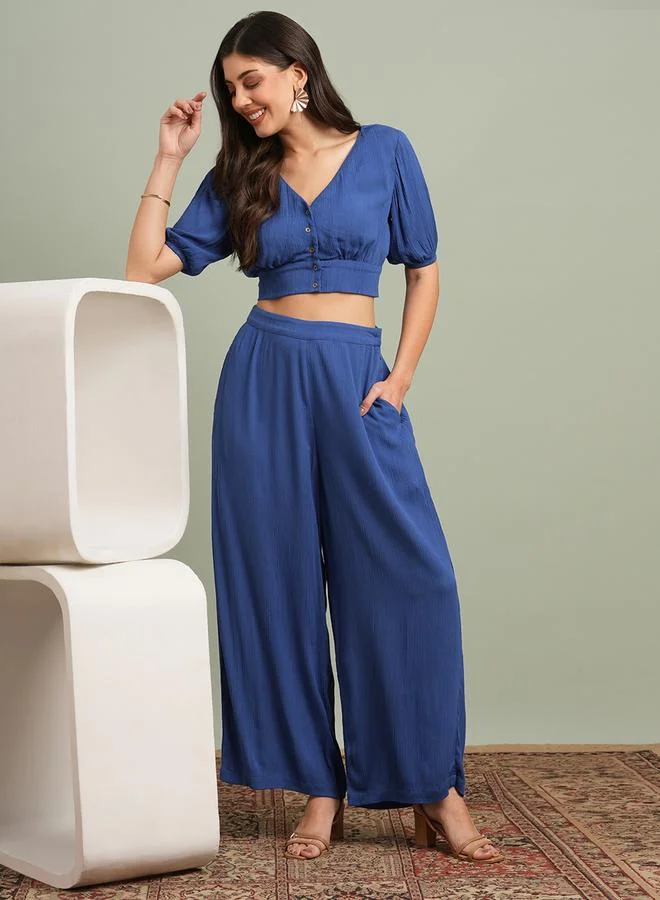 جلو باص طقم بلوزة قصيرة بأزرار مع بنطال بأرجل واسعة