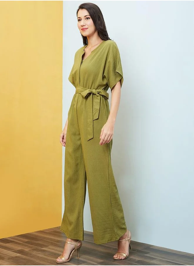 globus Globus Women Green Solid V-Neck Drop Shoulder Waist Tie-Up Jumpsuit by Styli