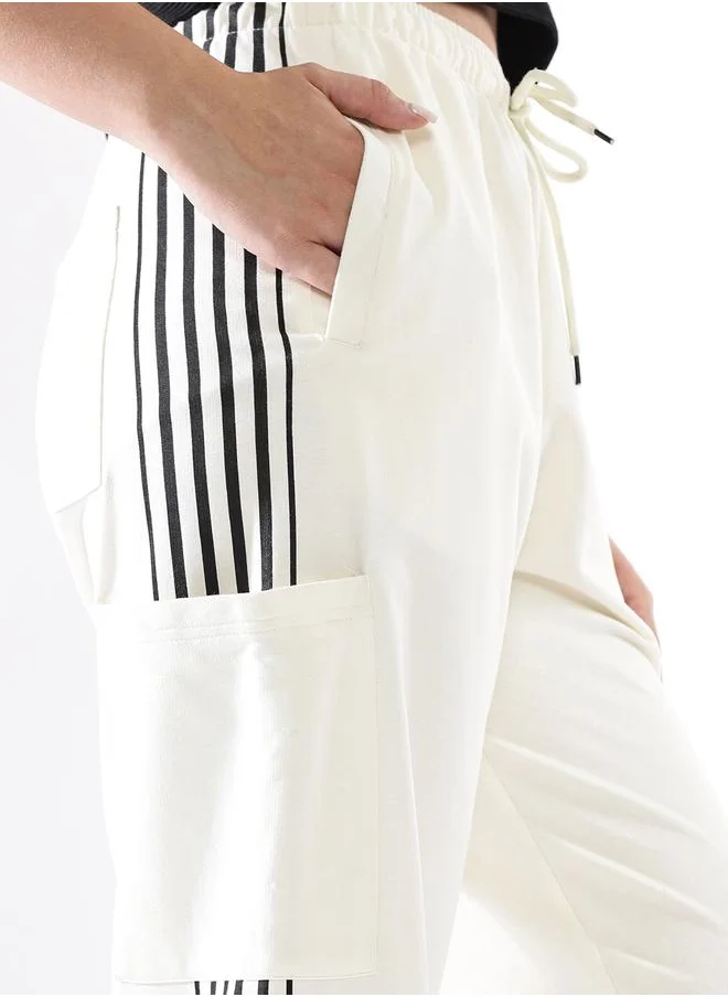HIGH STAR Women Track Pants in Off White featuring Wide Leg fit with a solid pattern, no sleeves, regular length, secured with elasicated + drawstring closure, crafted from terry – a must-have for those who love trendy fashion.
