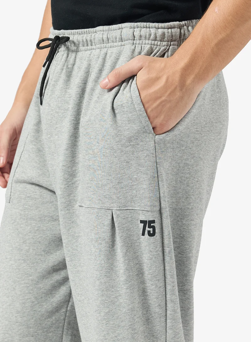 سفنتي فايف بيسيكس بنطلون رياضي واسع بتصميم ملصق