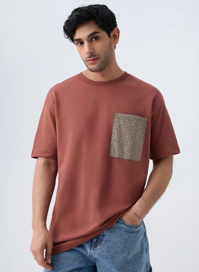 ذا سوليد ستور تيشيرت بقصة واسعة مع جيب مطبوع للرجال