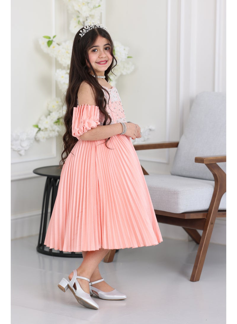 المصمم الحديث فستان سهرة بناتي تل يجمع بين فخامة اللؤلؤ المشكوك على الصدر ونعومة طبقات التل المنفوشة. يتميز بتنورة بليسيه قصيرة تمنح طفلتك إطلالة ملكية وحرية في الحركة، ليكون خيارك الأرقى في حفلات من براند المصمم الحديث - Image 2