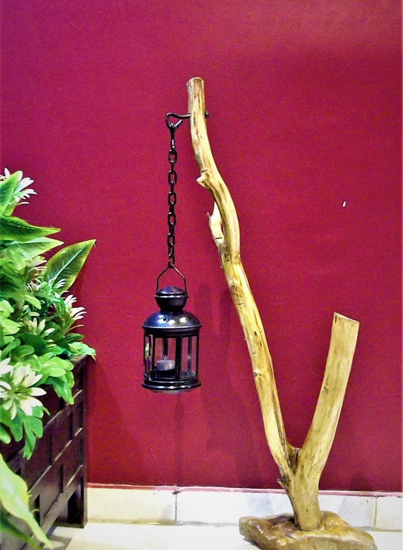 Black metal lantern fixed with a metal chain on a natural tree trunk  - Image 3