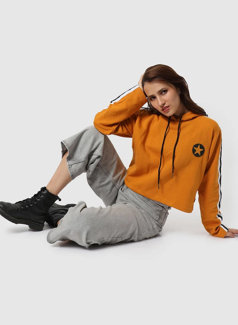 Campus Sutra Women's Mustard Yellow Star Crop Hoodie With Stripe Sleeve For Casual Wear | Hood Neck | Long Sleeve | Drawstring Closure | Cotton Sweatshirt Crafted With Comfort Fit For Everyday Wear | Mustard Yellow