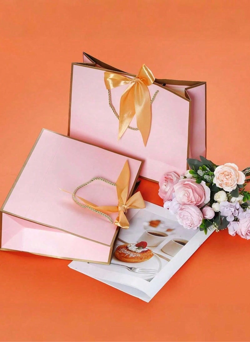 2 kraft paper gift bags with gold twisted rope handles and a pink silk satin ribbon to close the bag. Perfect for giving thoughtful gifts for weddings and bachelorette parties. - Image 3