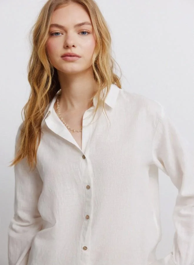 Linen long sleeve semi-open V-neck shirt with buttons on cuffs and front. This garment is made with sustainable cotton.