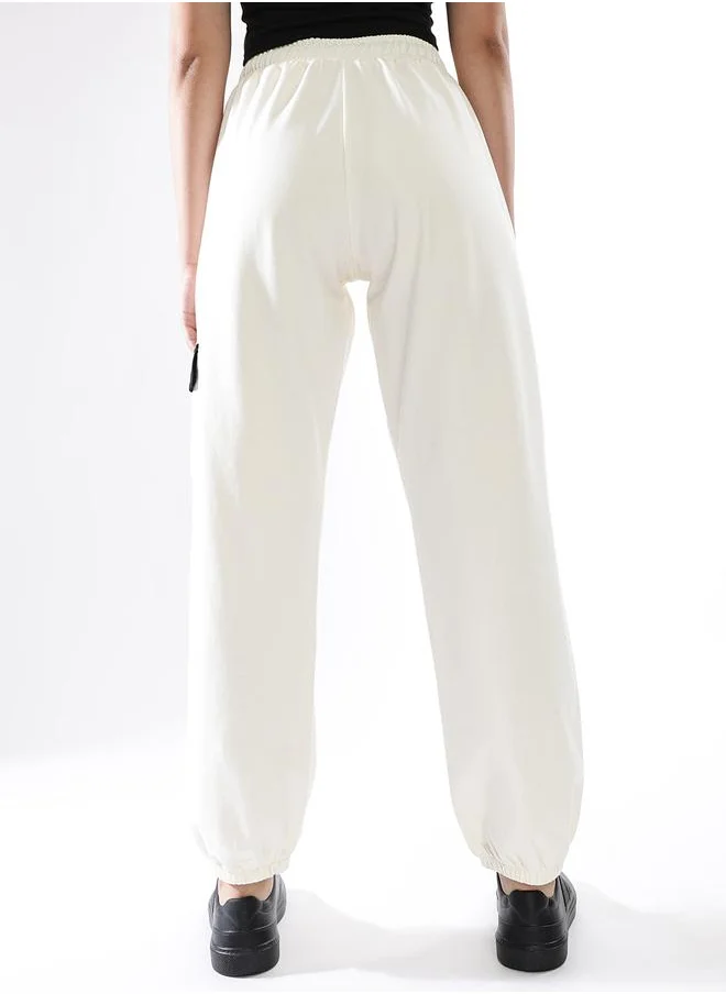 هوبرهولمي Women Track Pants in Off White featuring Jogger fit with a printed pattern, no sleeves, regular length, secured with elasicated + drawstring closure, crafted from terry – a trendsetting piece that blends fashion and comfort.