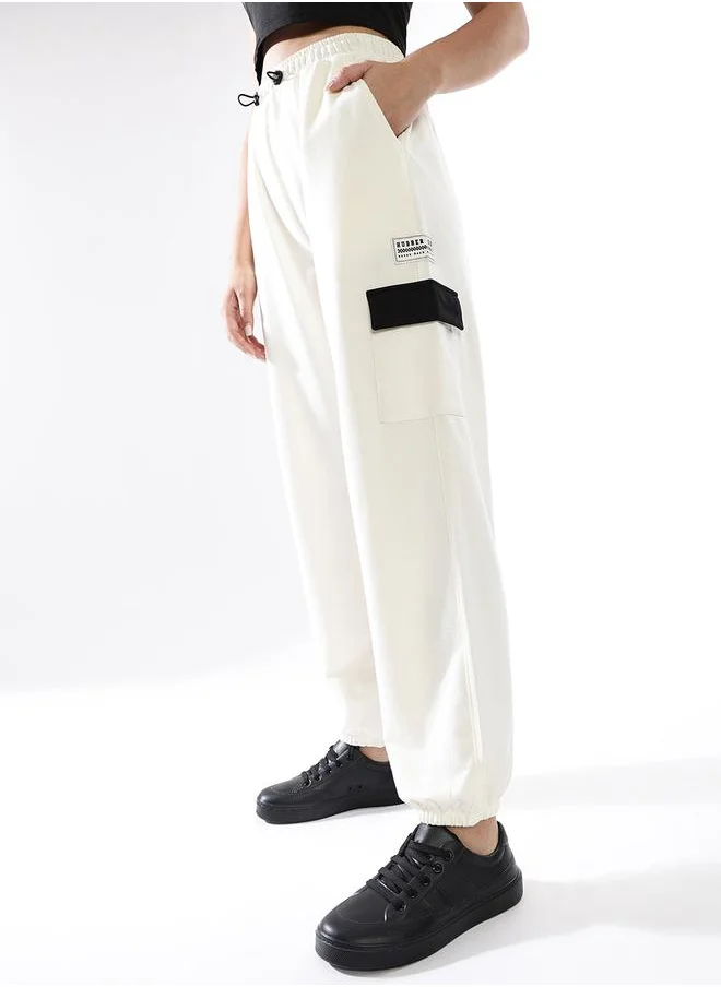 هوبرهولمي Women Track Pants in Off White featuring Jogger fit with a printed pattern, no sleeves, regular length, secured with elasicated + drawstring closure, crafted from terry – a trendsetting piece that blends fashion and comfort.