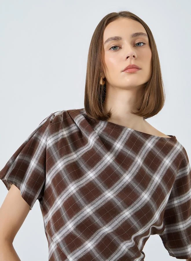 ستايلي بلوزة بنمط مربعات وتفاصيل كسرات