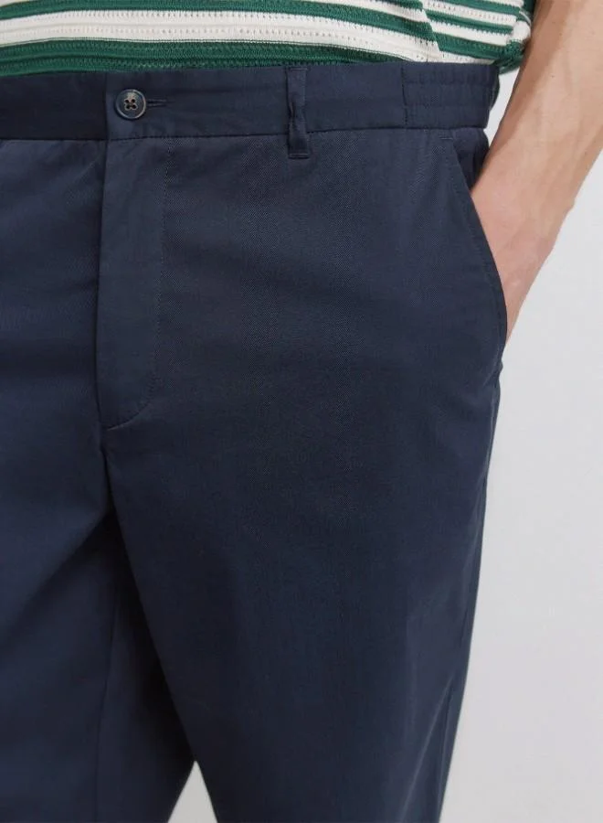Springfield  Trousers made from a lightweight cotton and nylon blend fabric with stretch, providing comfort. They feature an elasticated waistband on both sides for enhanced comfort, and an inner drawstring for a perfect fit. Back welt pockets with button. Relax fit. for Men | Best Price UAE
