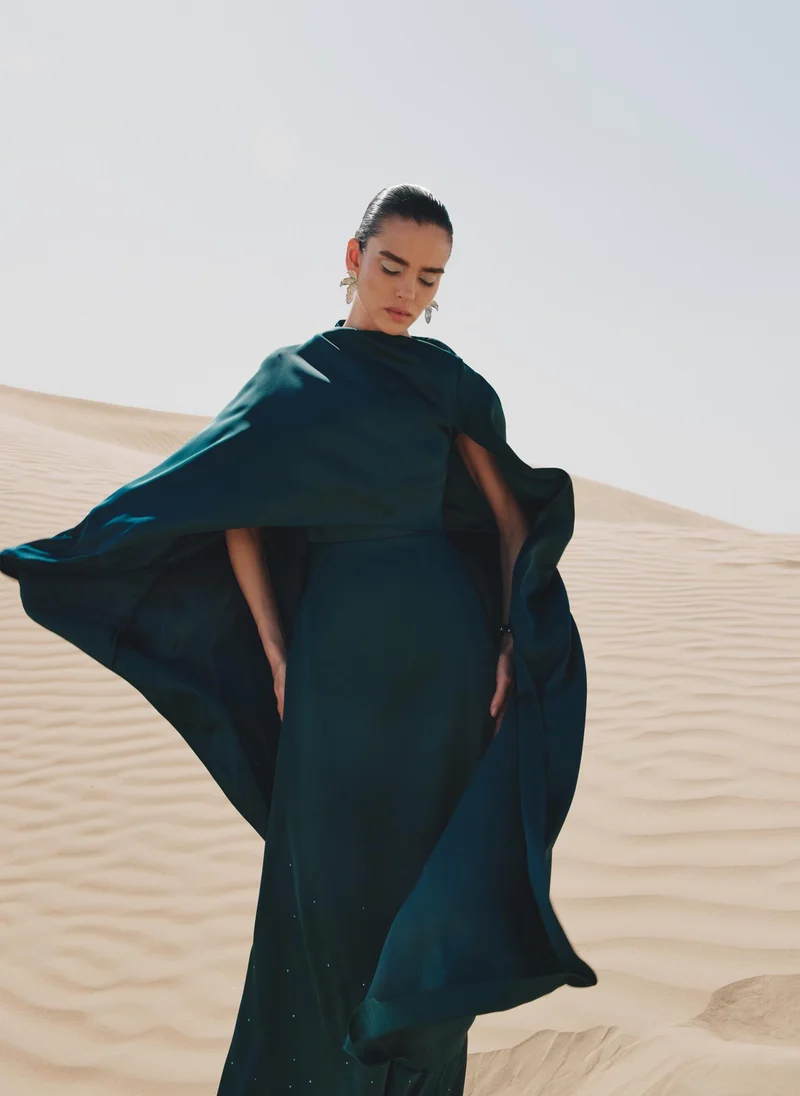 Lichi  Maxi dress with asymmetrical cape and rhinestones on the skirt for Women | Best Price UAE