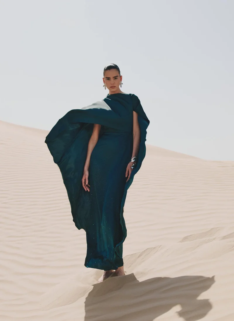 Maxi dress with asymmetrical cape and rhinestones on the skirt