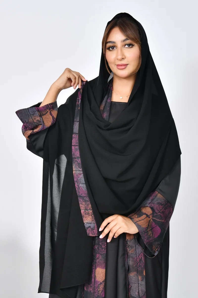 HAWRAA ABAYA A black, quarter-cloche abaya made of soft summer fabric with chiffon overlays on the sleeves and sides of the abaya.