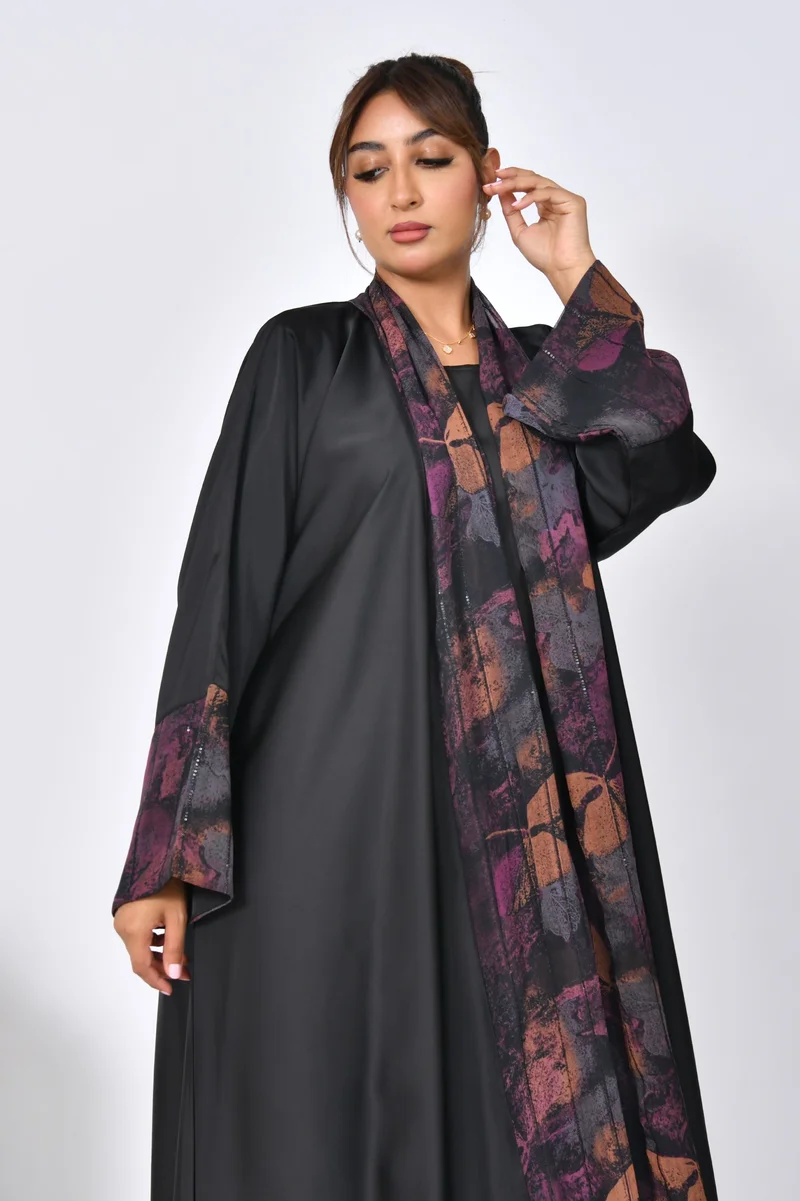 HAWRAA ABAYA A black, quarter-cloche abaya made of soft summer fabric with chiffon overlays on the sleeves and sides of the abaya.