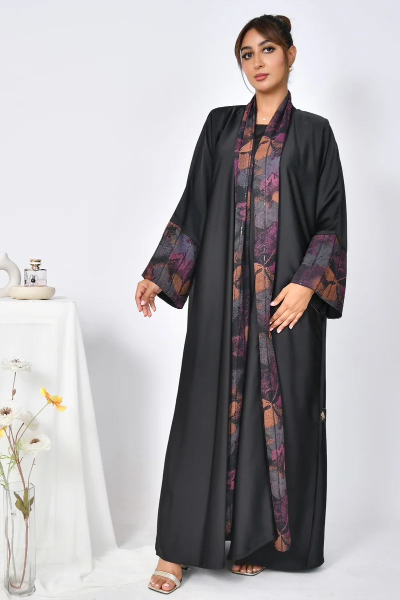 HAWRAA ABAYA A black, quarter-cloche abaya made of soft summer fabric with chiffon overlays on the sleeves and sides of the abaya.