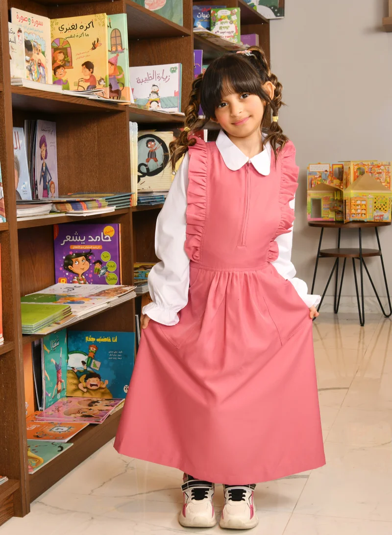 HAWRAA ABAYA Pink apron with long sleeves, ruffles on the shoulders, a zipper closure on the front, pleats at the bottom, and a tightening tie