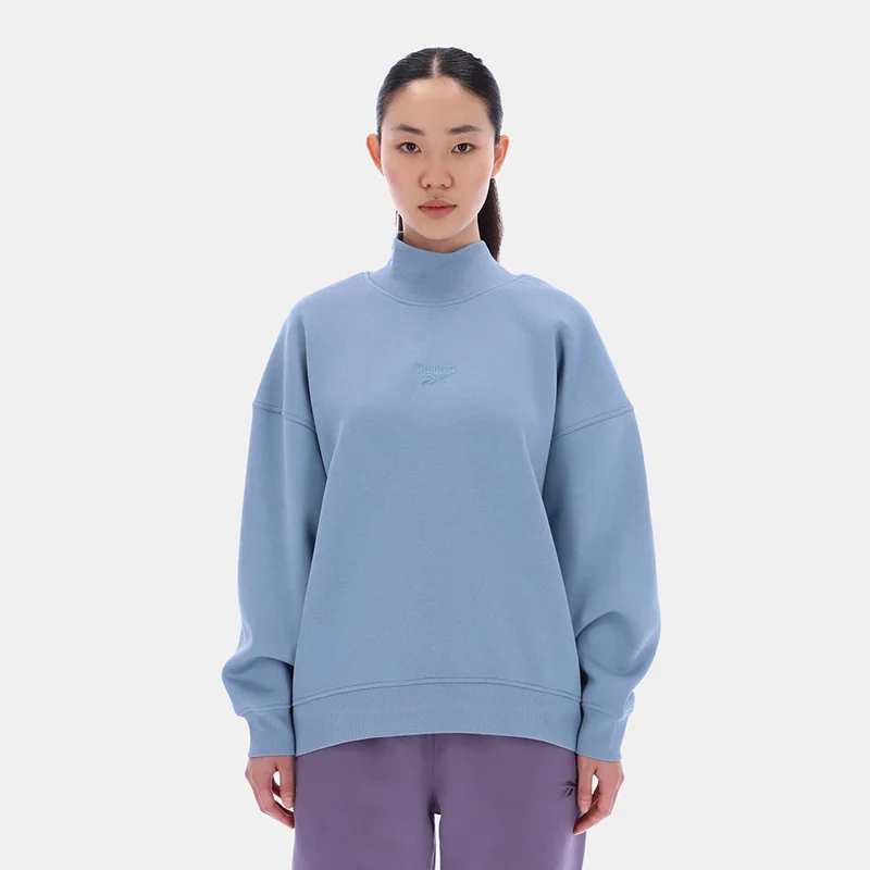 ريبوك Wrap yourself in feel-good vibes with this women's Reebok Sweatshirt. Soft brush-back fleece keeps you warm on chilly days, whether you're lounging or heading out. Extra length means extra coverage, and you get a Roll Neck for an extra-cozy touch.