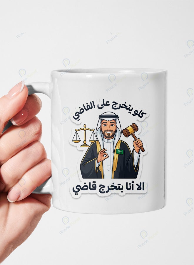 كوب سيراميك بطباعة عبارة كلو يتخرج على الفاضي إلا أنا بتخرج قاضي الشغف