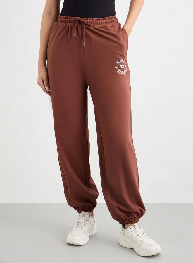 Styli Styli Brown Tapered Joggers with Graphic Print