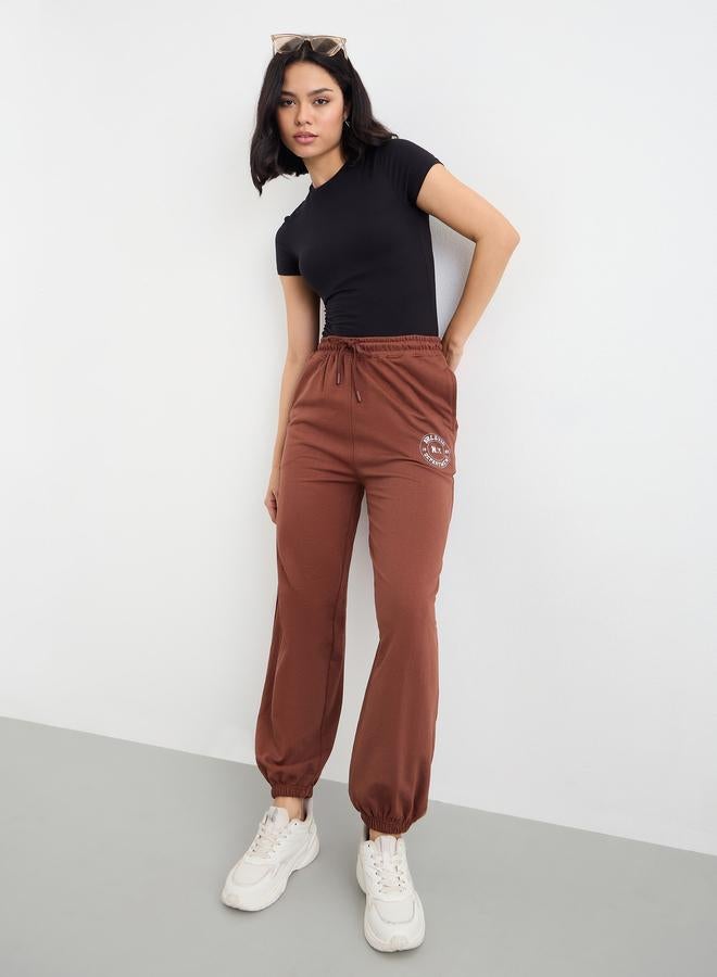 Styli Brown Tapered Joggers with Graphic Print - Image 1