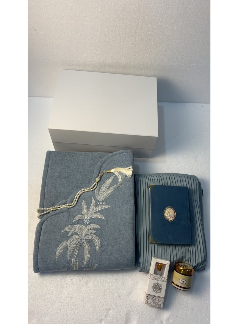 The comprehensive 6-piece prayer set (in "Hiba Blue") is an elegant and practical gift that combines reverence with comfort; it includes a padded prayer mat, a pleated prayer gown, a Quran, prayer beads, *mabthouth* (incense blend), and musk. - Image 2