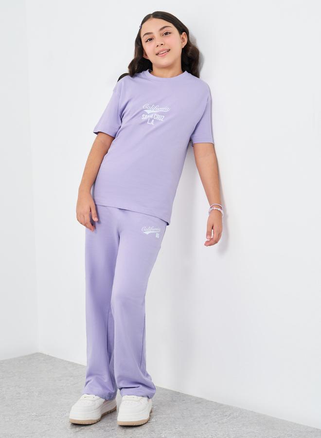 ستايلي طقم تي شيرت فضفاض بطبعة نص للبنات وسروال رياضي واسع الأرجل - Image 1