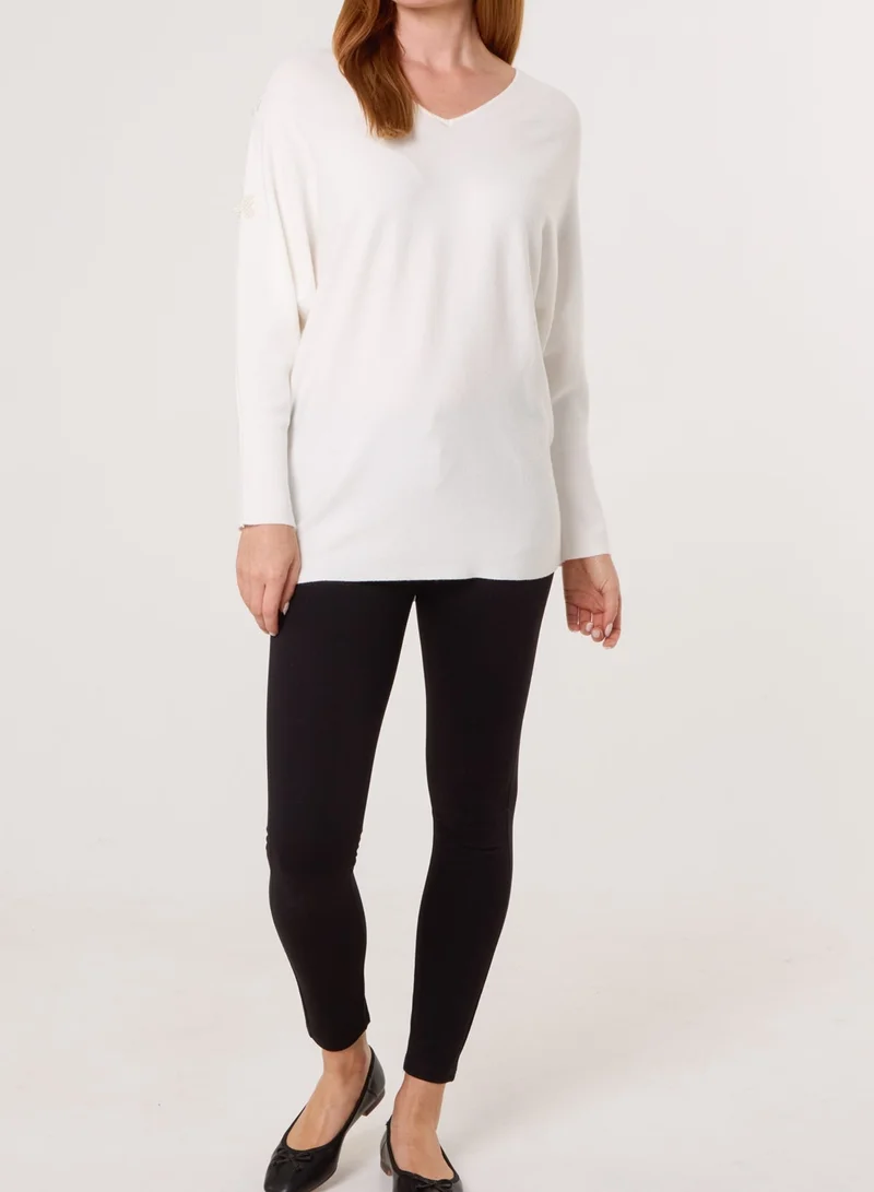 بلو فانيلا كنزة بياقة على شكل حرف  وأكمام خفاش وتفاصيل لؤلؤ