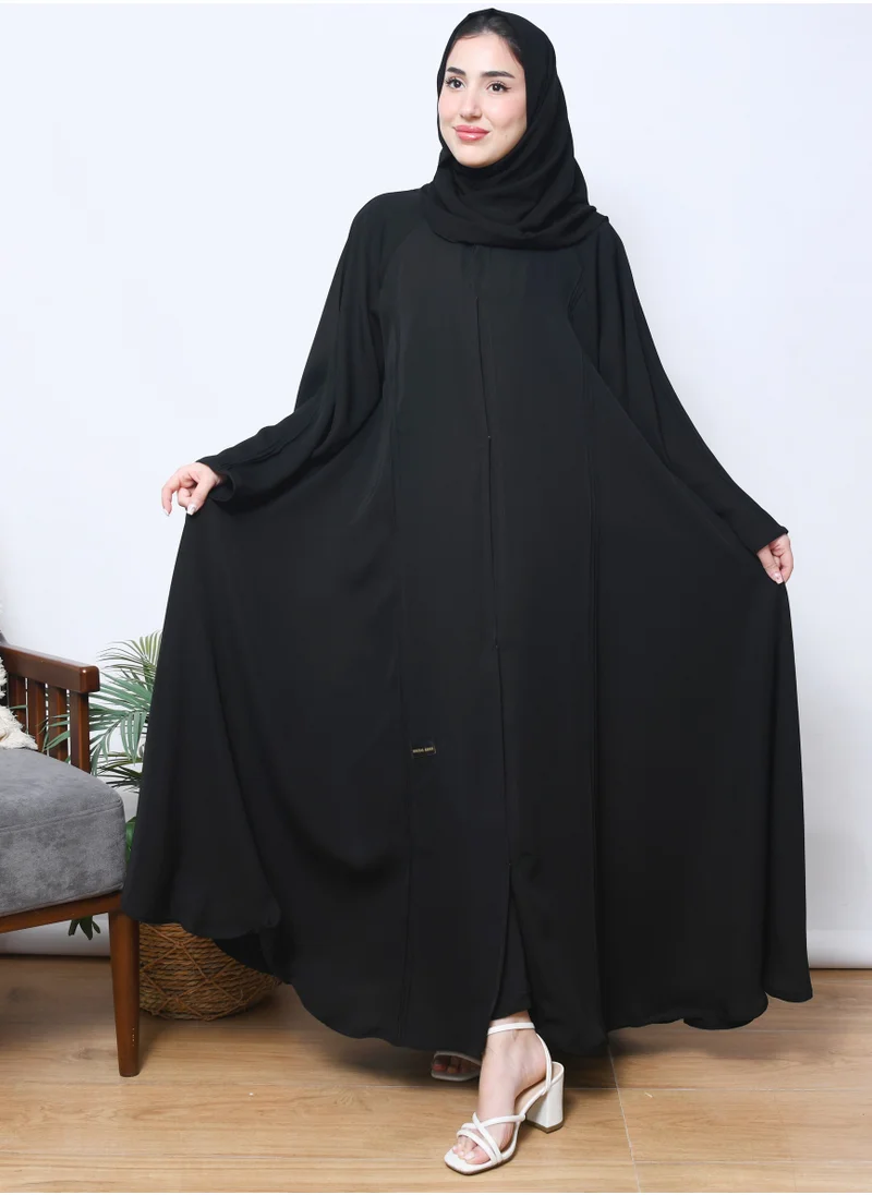 HAWRAA ABAYA A black cloche abaya closed with cuffs and longitudinal fabric pleats on the edges of the abaya and the sleeves