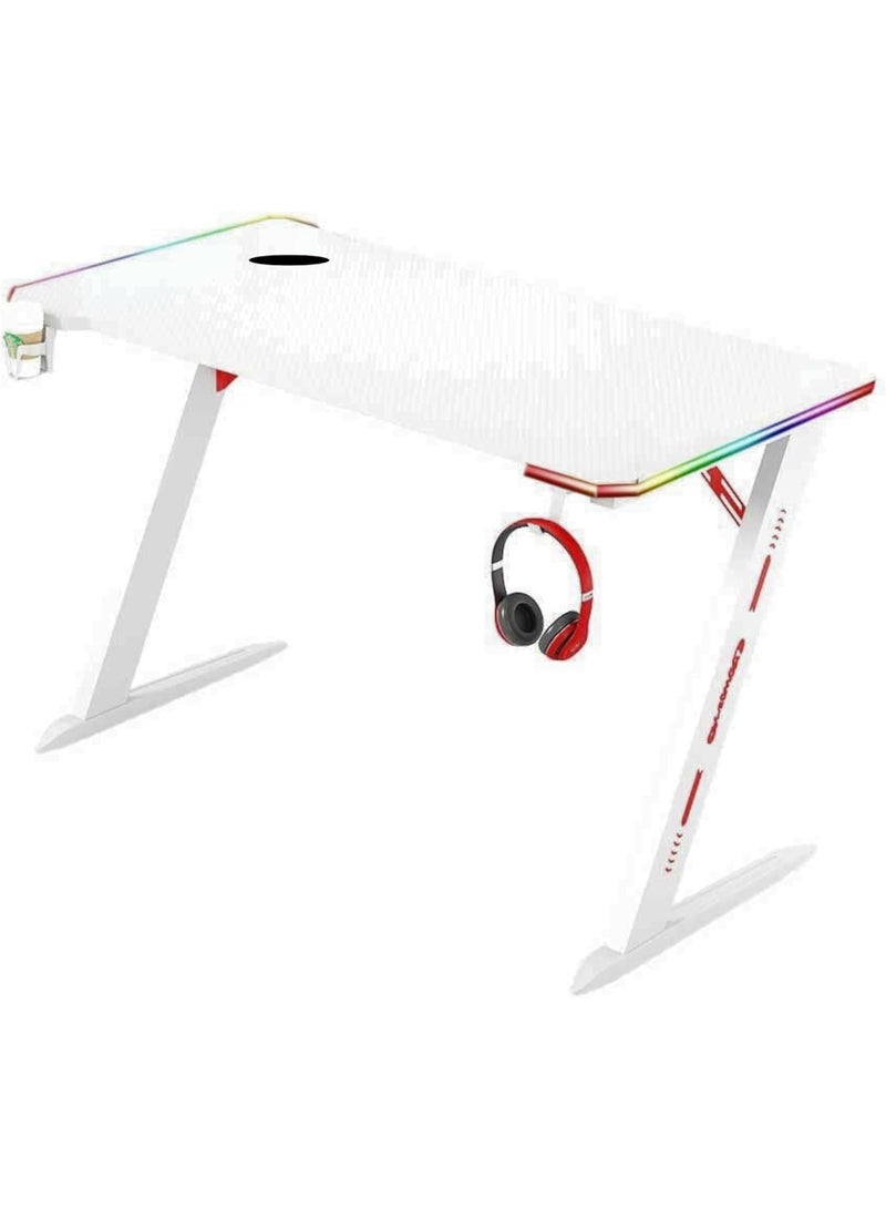 مكتب ألعاب مزود بإضاءة RGB، تصميم على شكل حرف Z، مقاس 140 × 60 × 73 سم، بسطح بنمط ألياف الكربون، مزود بحامل أكواب وخطاف لسماعة الرأس (أبيض) - Image 1