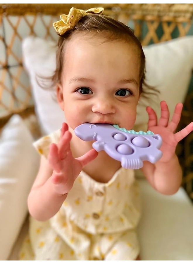 Itzy Ritzy - Itzy Ritzy Sensory Popper Toy - Itzy Pop Toy Features Raised Textures to Soothe Sore Gums; Relieves Stress and Improves Fine Motor Skills; Can Attach to a Bag or Pacifier Strap; Lilac Dinosaur - Image 1