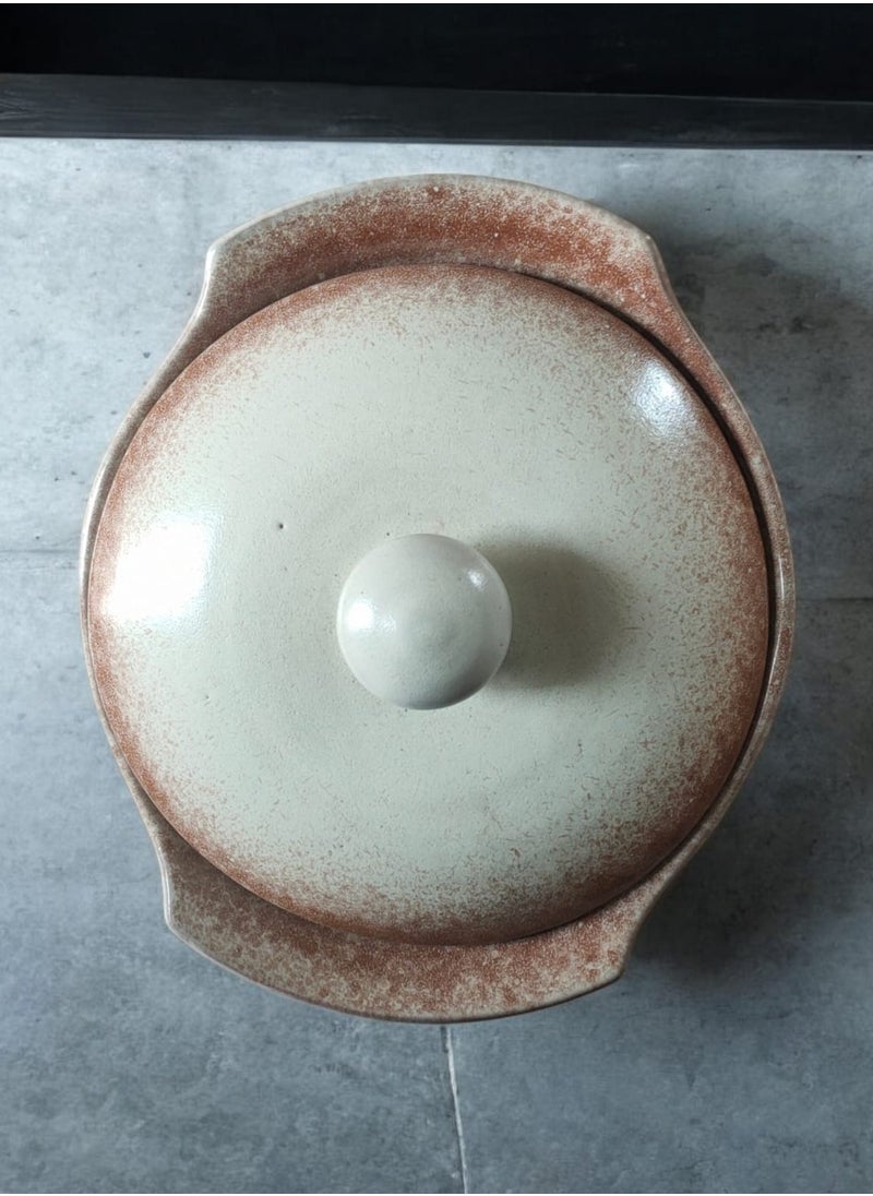 A pottery and porcelain pot with a lid that can withstand direct and indirect heat, from a flame or inside the oven.