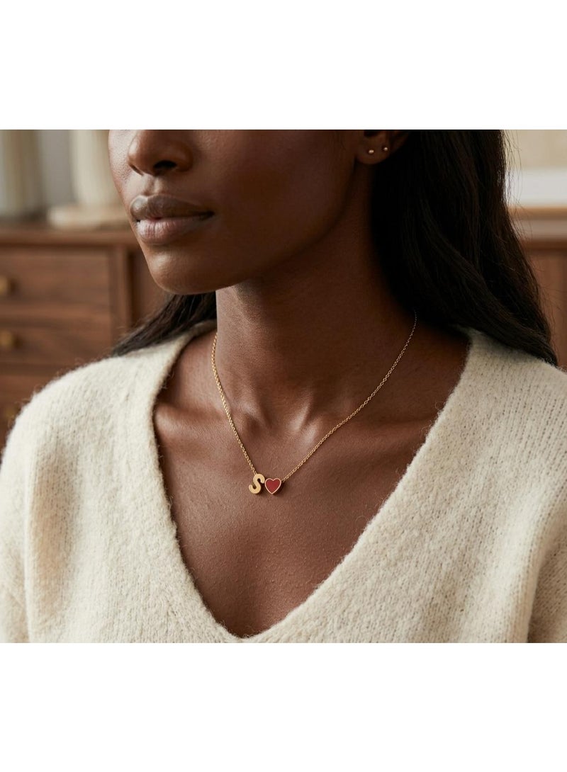 Luxuria A delicate necklace featuring an "S" pendant alongside a small, bright red heart charm, both in lustrous gold. This necklace is typically made of stainless steel. - Image 3