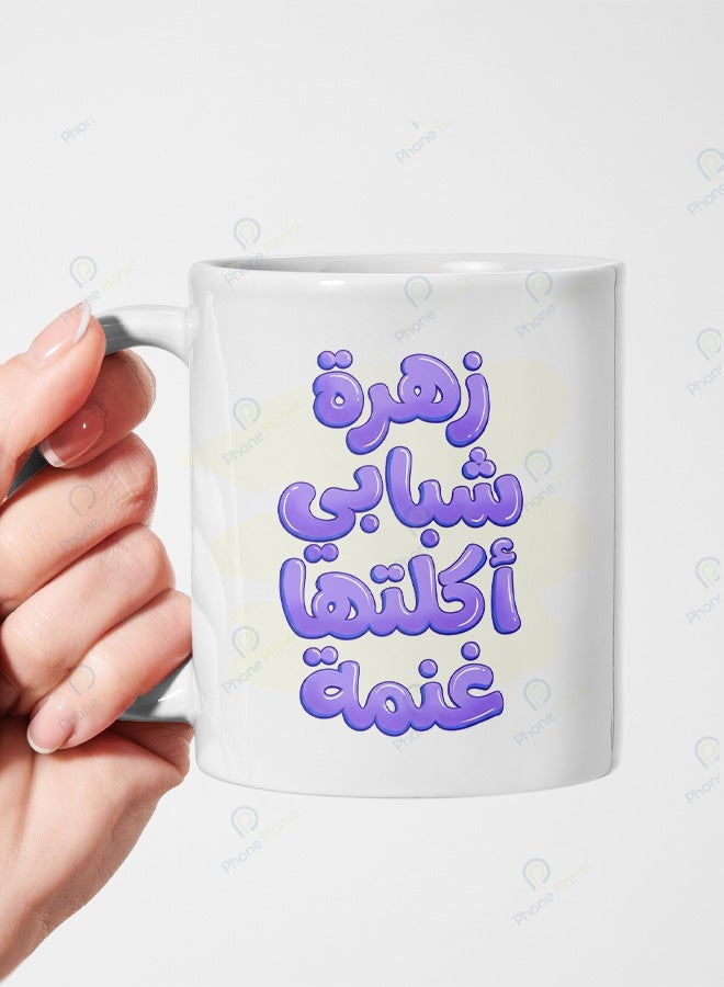 A ceramic mug printed with the phrase My youthful flower was eaten by a sheep and featuring a comfortable handle