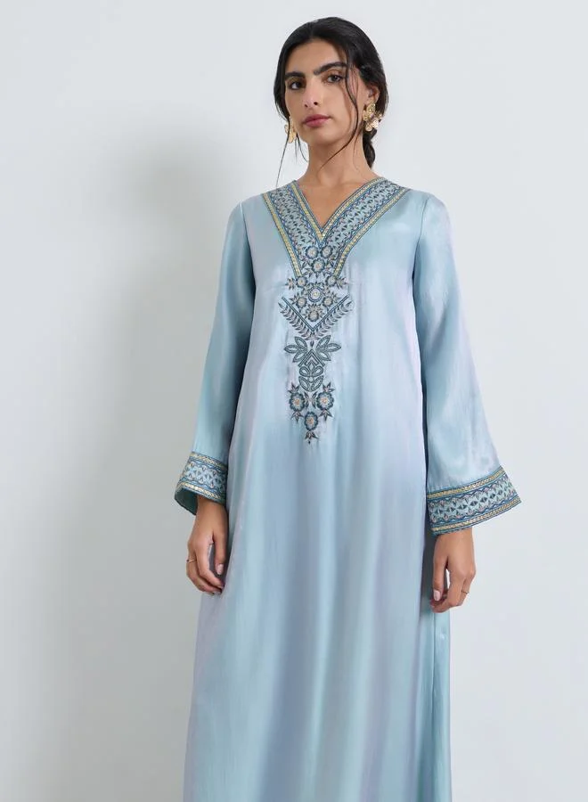 أميرة جلابية بفتحة رقبة على شكل حرف V وتطريز بخيوط زرقاء