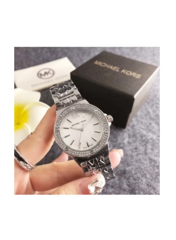 MK ساعة ميخايل كورس للنساء بلون فضي مع إطار مزين بالكريستال وشعار - سوار مفصل