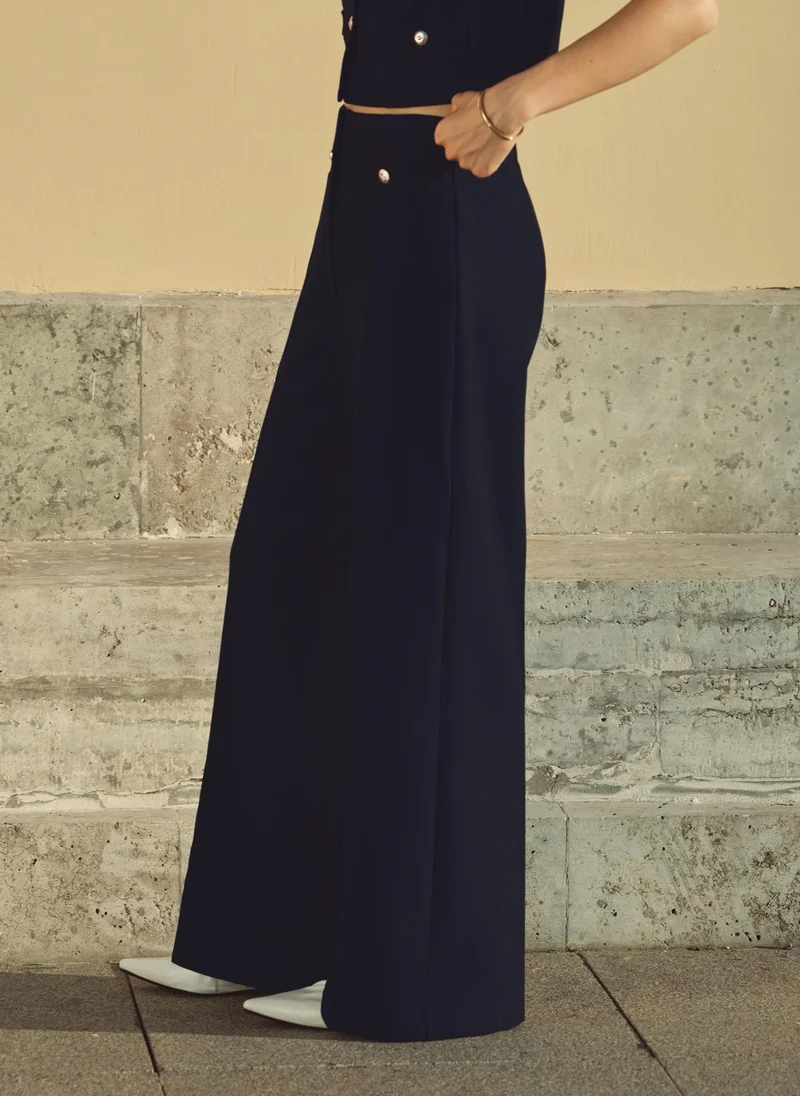 ليتشي بنطلون متوسط الارتفاع مع طيات أمامية وأزرار كبيرة الحجم